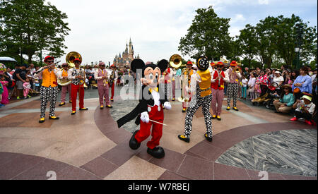 Ein Entertainer gekleidet in einem Mickey Maus Kostüm führt während einer Parade am ersten Jahrestag der zentralen Feier in der Shanghai Disneyland an Stockfoto