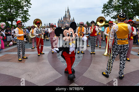 Ein Entertainer gekleidet in einem Mickey Maus Kostüm führt während einer Parade am ersten Jahrestag der zentralen Feier in der Shanghai Disneyland an Stockfoto