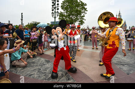 Ein Entertainer gekleidet in einem Mickey Maus Kostüm führt während einer Parade am ersten Jahrestag der zentralen Feier in der Shanghai Disneyland an Stockfoto