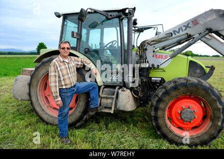 Christian Schmitt, Christian Schmitt, einen gemeinsamen Hamster freundlich Landwirt, vor seinem Traktor in einem Weizenfeld, Elsenheim, Elsass, Frankreich, Mai 2013 Stockfoto