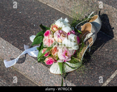 Ein Blumenstrauß für die Braut Schuhe auf dem Bürgersteig Stockfoto