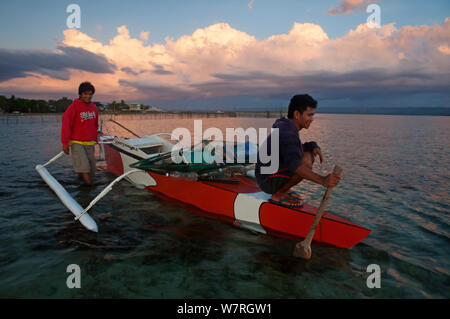 Fischer in bangka Boot bei Dämmerung abfliegen, Danajon Batasan Insel, Bank, Central Visayas, Philippinen, April 2013 Stockfoto