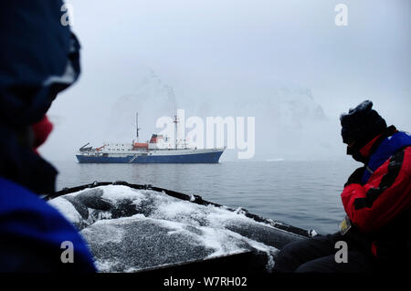 Touristen auf Zodiac Boot mit Antarktis Ushuaia Kreuzfahrtschiff 'MV' im Hintergrund Antarktische Halbinsel, Antarktis Stockfoto