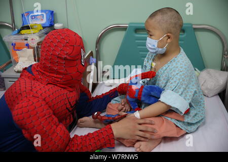 Ein chinesischer Mitarbeiter gekleidet wie Spiderman Geschenke gibt, um ein Kind in einer Gemeinde in der Hauptstadt Institut für Pädiatrie in Peking, China, 26. Mai 2017. Stockfoto