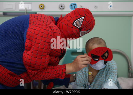 Ein chinesischer Mitarbeiter gekleidet wie Spiderman Photoss nimmt mit einem Kind in einer Gemeinde in der Hauptstadt Institut für Pädiatrie in Peking, China, 26. Mai 20. Stockfoto