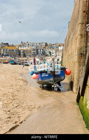 Angeln Boot günstig neben dem Leiter der Hafenmauer und Pier. St Ives, Cornwall, England, Vereinigtes Königreich Stockfoto