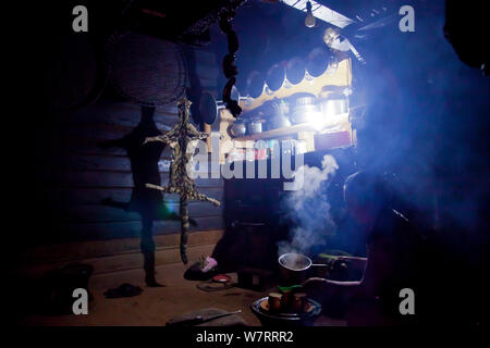 Nebelparder (neofelis Nebulosa) Haut in einer Küche hängen, die zu einem Naga Häuptling, mit einer Frau in der Nähe Kochen, Shatuza, Nagaland, Indien, 2011. Stockfoto
