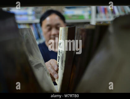 Yong Zhisheng, ein Manager in einem Wohnheim an der Sichuan moderne Berufsschule, liest ein Buch an der Schule Bibliothek in Chengdu City, im Südwesten von China" Stockfoto