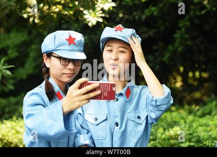 Chinesische Studenten der Schule des Marxismus, Zhejiang University, in der Roten Armee Uniformen gekleidet selfies vor dem Marsch in eine Parade auf dem Campus Stockfoto