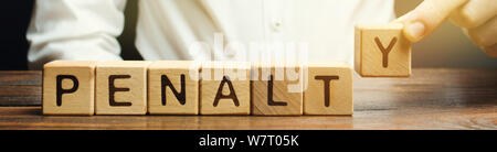 Ein Mann legt einen hölzernen Blöcke mit dem Wort Strafe. Feine als Strafe für ein Verbrechen und Vergehen. Verstöße gegen Verkehrsregeln. Legalisiert/finanzielle Puni Stockfoto
