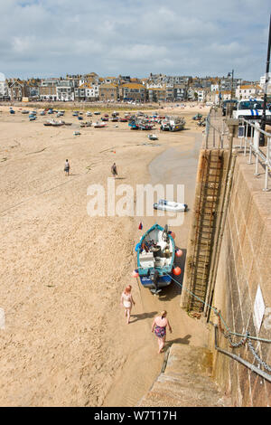 Angeln Boot günstig neben dem Leiter der Hafenmauer und Pier. St Ives, Cornwall, England, Vereinigtes Königreich Stockfoto