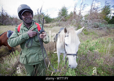 Wildlife Wilderei patrol Unit auf dem Pferd geben Radio update, Mount Kenya National Park, Kenia Stockfoto