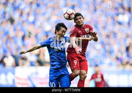 Brasilianische Fußballspieler Elkeson, rechts, von Shanghai SIPG, leitet die Kugel gegen Tao Jin von Shanghai Shenhua Grönland in der 10. Runde dur Stockfoto