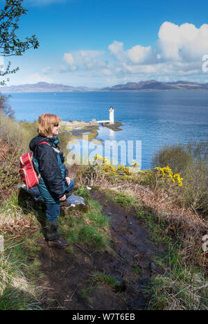 Frau Wanderer erfreuen sich an der Aussicht zu Rubha Nan Gall Leuchtturm, nördlich von Tobermory, Isle of Mull, Schottland, UK, Mai 2013. Stockfoto