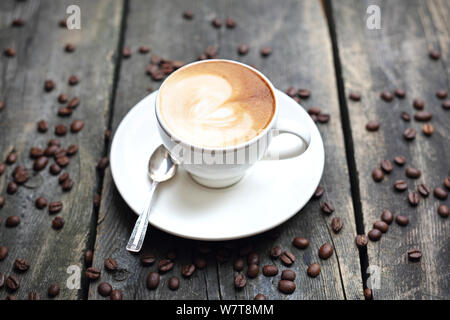 Kaffee in einer Tasse auf einem hölzernen Hintergrund Stockfoto