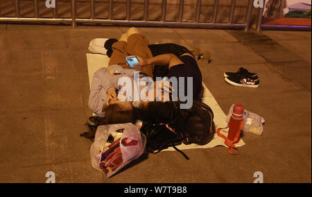 Die Passagiere schlafen auf dem Platz von Zhengzhou Bahnhof in Zhengzhou City, Central China Provinz Henan, 18. Mai 2017. Hunderte von passenge Stockfoto