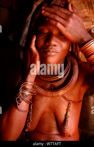 Himba Frau Otjize (eine Mischung aus Butter, Ocker und Asche) auf ihrer Haut, Kaokoland, Namibia, September 2013 anzuwenden. Stockfoto