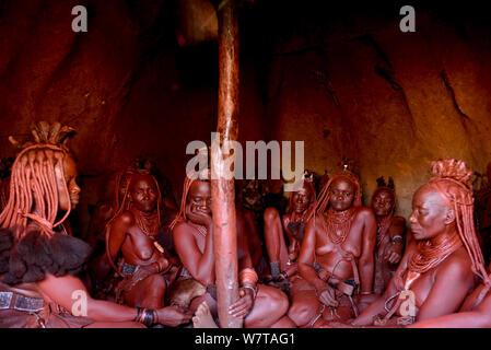 Himba Frauen in eine Hütte, Kaokoveld, Namibia sitzen, September 2013. Stockfoto
