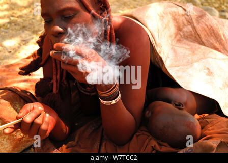 Frau Himba rauchen Schnupftabak, Namibia, Februar 2005. Stockfoto