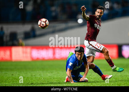 Argentinische Fußballspieler Ezequiel Lavezzi von Hebei China Fortune, rechts, Herausforderungen Jiang Zhipeng von Guangzhou R&F in der 9. Runde während des Th Stockfoto