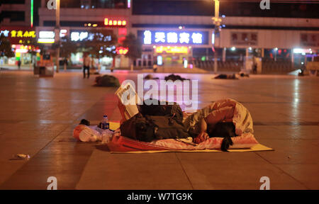 Die Passagiere schlafen auf dem Platz von Zhengzhou Bahnhof in Zhengzhou City, Central China Provinz Henan, 18. Mai 2017. Hunderte von passenge Stockfoto