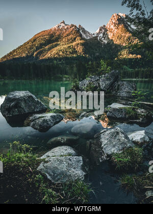 Fantastischer Sonnenaufgang am Hintersee. Schöne Szene von Bäumen auf einer Insel im Frühling Stockfoto