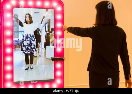 Eine Frau versucht, auf der Kleidung mit Hilfe eines virtuellen 3D-Verschraubung Zimmer in einem Einkaufszentrum in Nanjing, der ostchinesischen Provinz Jiangsu, 8. Mai 2017. Verbraucher versucht, o Stockfoto