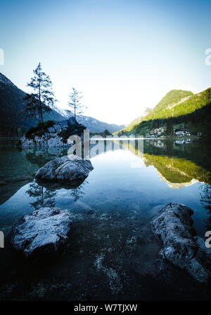 Fantastischer Sonnenaufgang am Hintersee. Schöne Szene von Bäumen auf einer Insel im Frühling Stockfoto