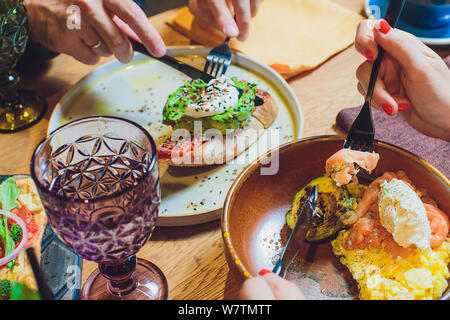 Vollkornbrot Sandwiches mit gebratenen Wachtelei, Avocado, Kräuter und Samen auf schwarzem Hintergrund. Sauber Essen, gesund vegan Frühstück. Stockfoto