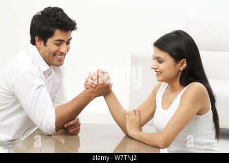 Junge Frau Armdrücken mit ihrem Ehemann Stockfoto