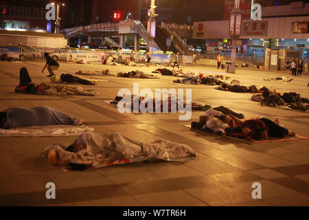 Die Passagiere schlafen auf dem Platz von Zhengzhou Bahnhof in Zhengzhou City, Central China Provinz Henan, 18. Mai 2017. Hunderte von passenge Stockfoto