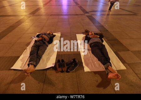 Die Passagiere schlafen auf dem Platz von Zhengzhou Bahnhof in Zhengzhou City, Central China Provinz Henan, 18. Mai 2017. Hunderte von passenge Stockfoto