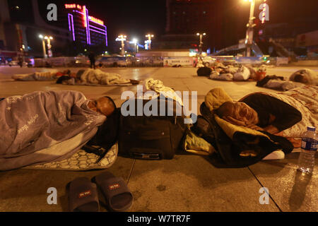 Die Passagiere schlafen auf dem Platz von Zhengzhou Bahnhof in Zhengzhou City, Central China Provinz Henan, 18. Mai 2017. Hunderte von passenge Stockfoto