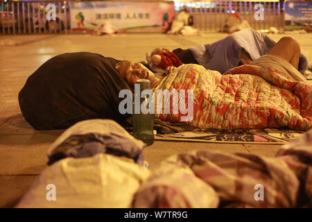 Die Passagiere schlafen auf dem Platz von Zhengzhou Bahnhof in Zhengzhou City, Central China Provinz Henan, 18. Mai 2017. Hunderte von passenge Stockfoto