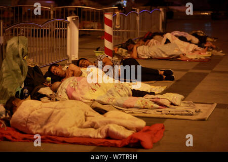 Die Passagiere schlafen auf dem Platz von Zhengzhou Bahnhof in Zhengzhou City, Central China Provinz Henan, 18. Mai 2017. Hunderte von passenge Stockfoto