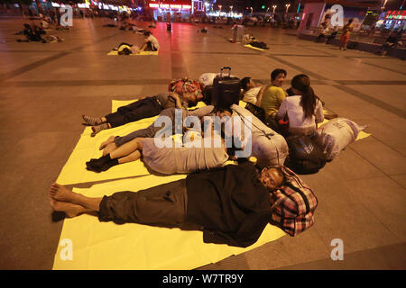 Die Passagiere schlafen auf dem Platz von Zhengzhou Bahnhof in Zhengzhou City, Central China Provinz Henan, 18. Mai 2017. Hunderte von passenge Stockfoto