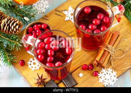 Weihnachten, Thanksgiving Getränke close-up. Heißer Winter trinken mit Preiselbeeren und Zimt auf Holztisch. Stockfoto