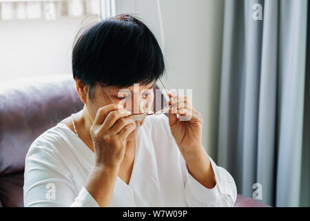 Porträt der alten Frau, die ihre Brille Stockfoto