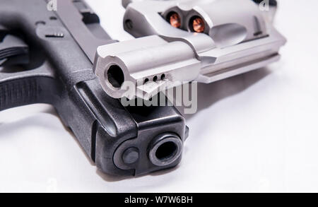 Zwei Pistolen, ein silberner snub Spitzzange 357 Magnum Revolver und ein schwarzes 9-mm-Pistole auf weißem Hintergrund Stockfoto