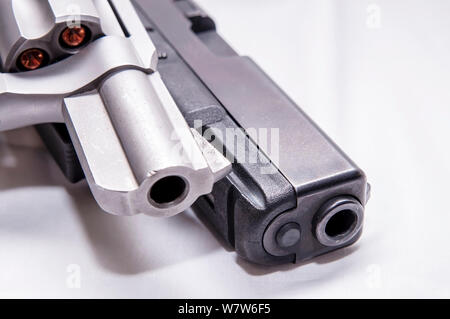 Zwei Pistolen, ein silberner snub Spitzzange 357 Magnum Revolver und ein schwarzes 9-mm-Pistole auf weißem Hintergrund Stockfoto