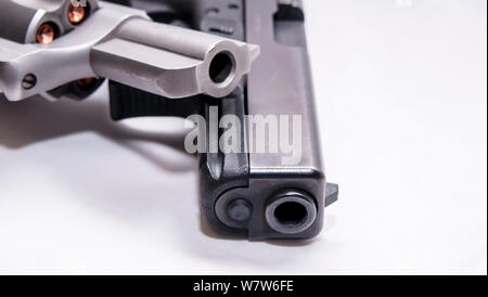 Zwei Pistolen, ein silberner snub Spitzzange 357 Magnum Revolver und ein schwarzes 9-mm-Pistole auf weißem Hintergrund Stockfoto