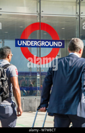 Zwei Geschäftsleute auf sich morgens auf dem Weg zur Arbeit am Eingang zur U-Bahnstation Victoria, Central London. Stockfoto