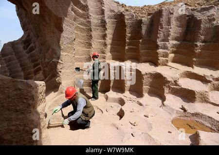 Chinesische Arbeiter graben das 600 Jahre alte Mühlstein gruben sich in einer 7.000 Quadratmeter Mühlsteine verwendet Reis und Bohnen zu Schleifen zu bekommen Stockfoto