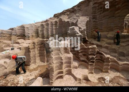 Chinesische Arbeiter graben das 600 Jahre alte Mühlstein gruben sich in einer 7.000 Quadratmeter Mühlsteine verwendet Reis und Bohnen zu Schleifen zu bekommen Stockfoto