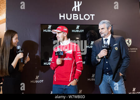 Die deutschen F1 Fahrer Sebastian Vettel von Ferrari, Mitte, besucht eine Wiedereröffnung für uhrenmarke Hublot im Plaza 66 Shopping Mall in Shanghai, China Stockfoto