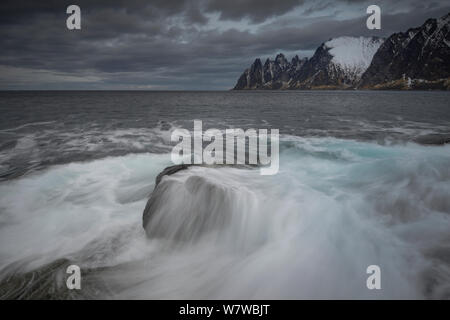 Blick über Norwegische See von Tungeneset, Richtung Okshornan Bergkette bedeckt im Schnee, Insel Senja, Troms, Norwegen, Februar 2014. Stockfoto