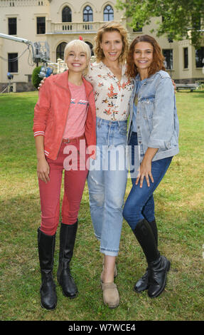 06. August 2019, Brandenburg, Reichenow: Auf einem pressetermin am Set von "The Amazon Serie Bibi und Tina vor Schloss Reichenow, (L - r) Schauspielerin Katharina Hirschberg wie Bibi, die schauspielerin Franziska Weisz wie Tinas Mutter Susanne Martin und Schauspielerin Harriet Herbig-Matten als Tina stehen (L-R). Die Dreharbeiten für den neuen Amazon Original Bibi & Tina ist derzeit in Berlin. Der Live Action Serie für die ganze Familie begleitet die junge Hexe Bibi Blocksberg und ihre beste Freundin Tina auf ihre Abenteuer auf dem Reiterhof. Die neue Serie ist bis Mitte geschossen - August und Nutzen sein werden. Stockfoto