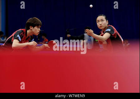 Mima Ito, rechts, dient als Sie und Masataka Morizono von Japan gegen Fang Bo und Wang Manyu China konkurrieren in Ihrer gemischten Doppel Halbfinale Stockfoto