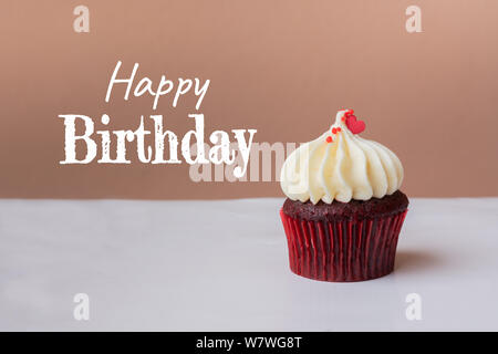 Happy Birthday süße Cupcake mit kleinen roten Herzen auf rosa Hintergrund Stockfoto