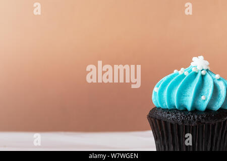 Cute Cupcake mit kleinen weißen Schnee blau Creme auf weißem Hintergrund Stockfoto